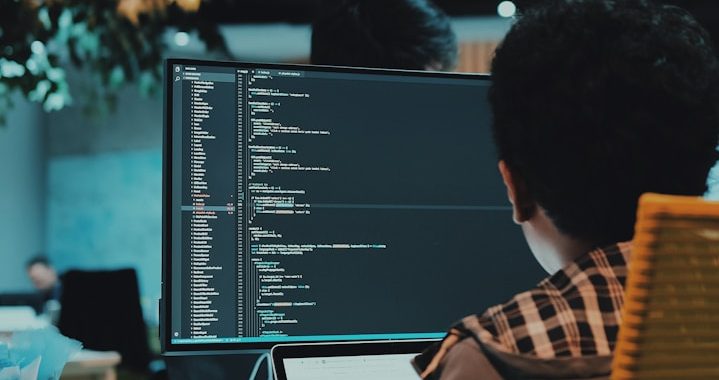 Análisis de datos ómicos Persona programando en una computadora con código en pantalla.